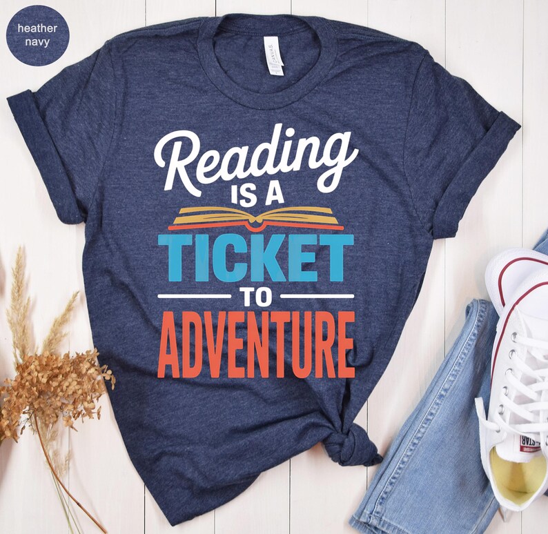 Navy t-shirt with "Reading is a ticket to adventure" text and book graphic.