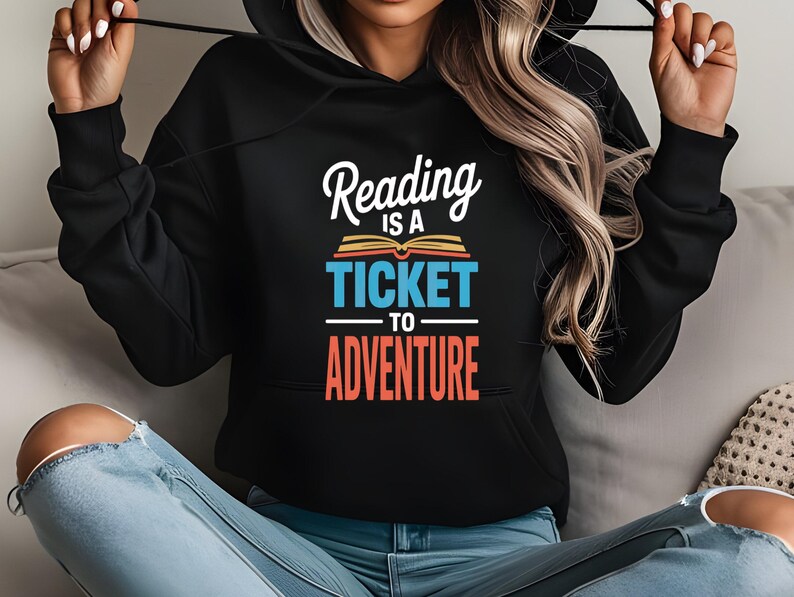 Black hoodie with "Reading is a ticket to adventure" and an open book graphic.