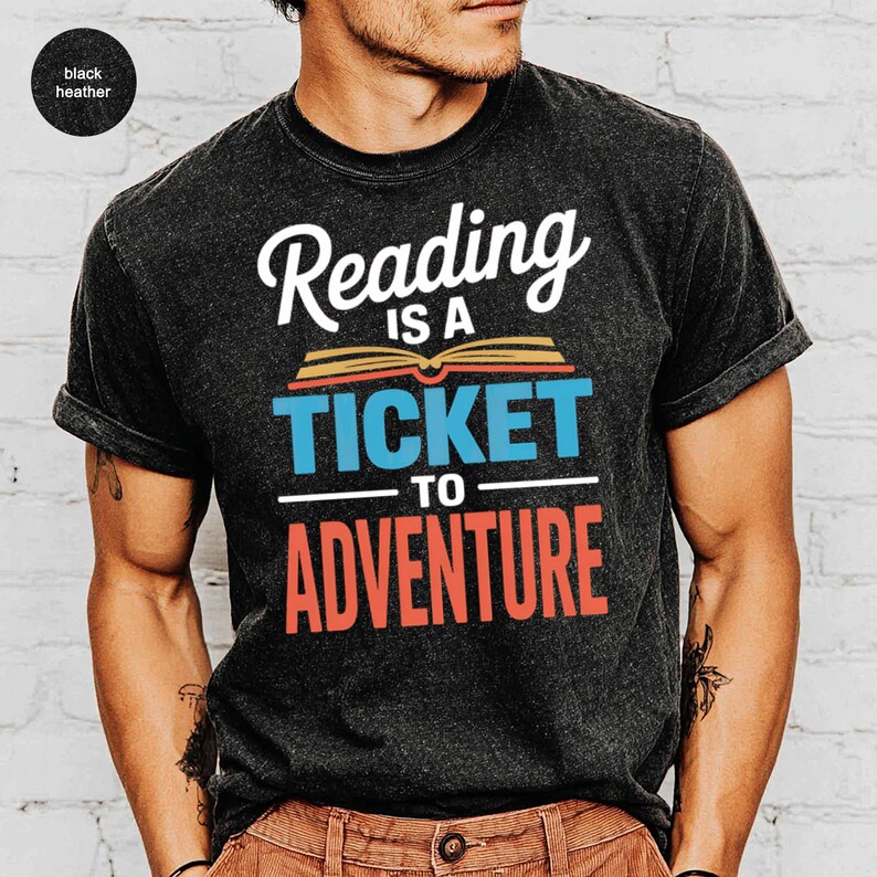 Black t-shirt with "Reading is a ticket to adventure" text and a book graphic.