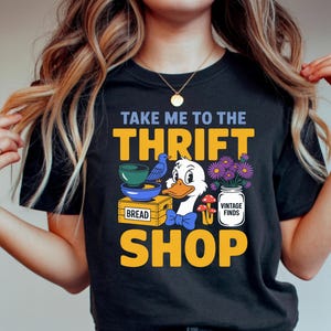 May include: A white ceramic mug with a black handle and the text "But First, Coffee" in a black, bold font. The mug is on a white surface.