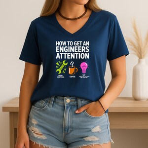 Navy V-neck t-shirt with "How to Get an Engineer's Attention" and three icons.