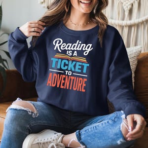 Navy sweatshirt with "Reading is a ticket to adventure" text.