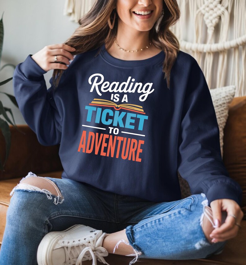 Navy sweatshirt with "Reading is a ticket to adventure" text.