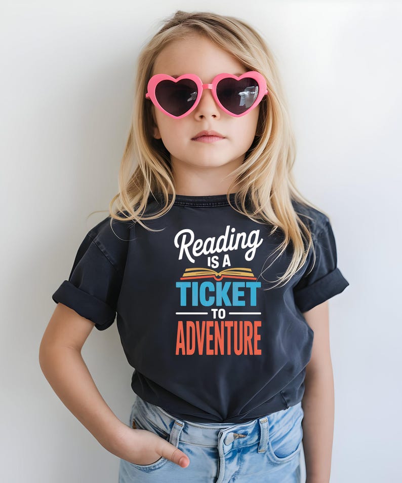 Girl wearing t-shirt with "Reading is a ticket to adventure" text.