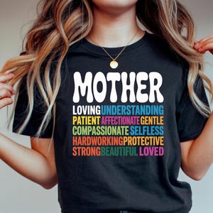 May include: A white ceramic mug with a black handle and the text "But First, Coffee" in a bold, black font. The mug is set against a blurred background, suggesting a cozy setting.