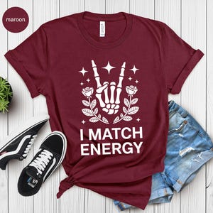 I Match Energy, Skeleton Hand Rock On, Rose Graphic Tee, Witchy Aesthetic, Empowering Vibes, Trendy Goth Design, Dark Art Print
I Match