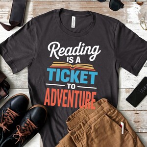 Dark gray t-shirt with "Reading is a ticket to adventure" text.