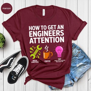 Maroon t-shirt with text "How to Get An Engineers Attention" and icons.