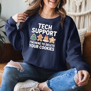 May include: Navy blue sweatshirt with the text "TECH SUPPORT I'M HERE TO DELETE YOUR COOKIES" in white. The design includes gingerbread cookie graphics. The sweatshirt is a crew neck style.