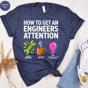 T-shirt with text "How to get an engineer's attention" and icons for breaking, coffee, and a lightbulb.