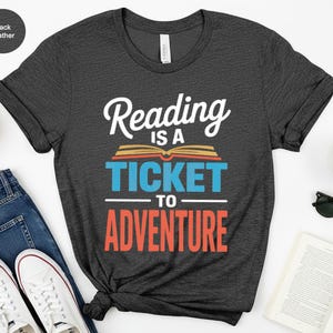 Black t-shirt with "Reading Is A Ticket To Adventure" text.