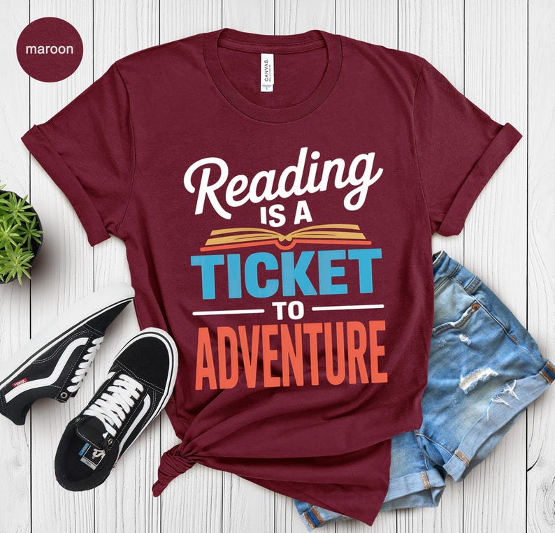 Maroon t-shirt with "Reading is a ticket to adventure" text.