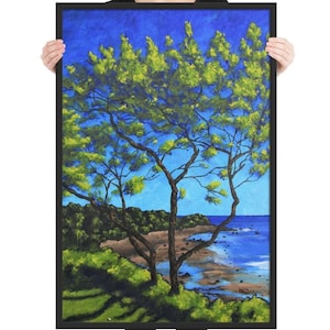 May include: A painting of a tree with green leaves against a blue sky. The tree is in the foreground and the ocean is in the background. The painting is framed in black.