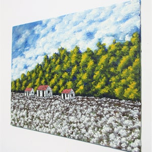 May include: A painting of a rural landscape with three white houses with red roofs in a field of white cotton. The houses are in front of a line of green trees with yellow leaves. The sky is blue with white clouds.