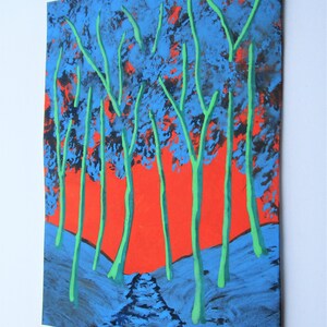 May include: A painting depicting a forest scene with tall, green trees against a bright orange sky. The trees are painted in a stylised way, with thick, dark blue trunks and branches. The sky is a vibrant orange, with hints of red and yellow. The ground is covered in a dark blue and black paint, suggesting a forest floor.