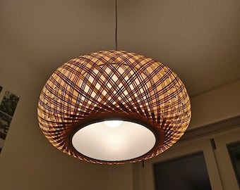May include: A woven wicker pendant light with a white fabric shade. The light is hanging from a ceiling and is turned on.