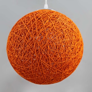 May include: Orange woven pendant light fixture with a spherical shape.