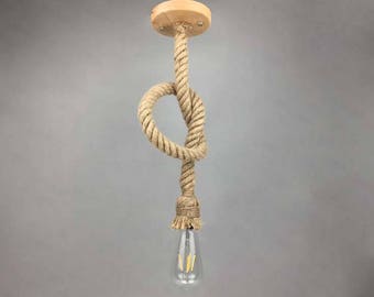 May include: A pendant light fitting with a natural rope cord and a wooden ceiling mount. The rope is knotted and the light bulb is a clear glass Edison bulb.