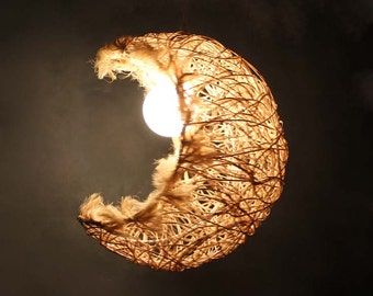 May include: A crescent moon-shaped light fixture made of woven natural fibers with a light bulb inside.