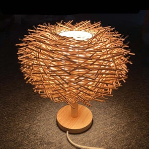 table lamp,bedside table lamp,desk lamp,housewarming table lamp,nightstand lamp,Handmade table lamp
Rattan woven light
Bohemian decor
Natural rattan lamp
Wooden base lamp
Eco-friendly lighting
Rustic table light
Unique home decor
Customizable lamp
Handcrafted fixture
Modern boho lamp
Gift for home
Sustainable decor