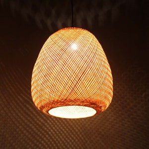 May include: A woven, round, light brown pendant lamp with a white light shining through the weave.
