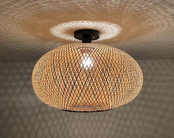 May include: A woven bamboo ceiling light fixture with a natural brown color. The light fixture has a round shape and a criss-cross pattern.