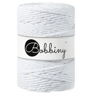 May include: A spool of white macrame cord with the brand name "Bobbiny" on a white label. The cord is tightly wound, showing a textured surface. Ideal for crafting projects.