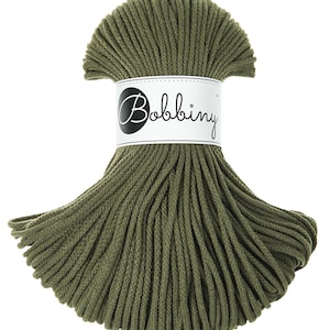 Può includere: Un rotolo di cordoncino di cotone verde, etichettato "Bobbiny", per progetti di artigianato.