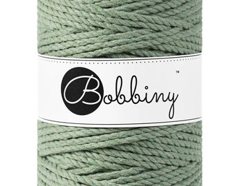 Könnte beinhalten: Eine Rolle aus salbeigrünem Baumwollseil mit einem weißen Etikett, auf dem "Bobbiny™" steht.