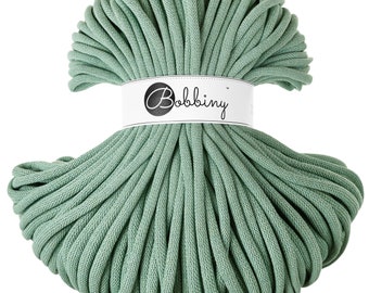 May include: A large spool of sage green cotton cord, labeled "Bobbiny".