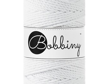 Könnte beinhalten: Eine weiße Spule aus Baumwollseil mit dem Markennamen "Bobbiny" auf einem Etikett.