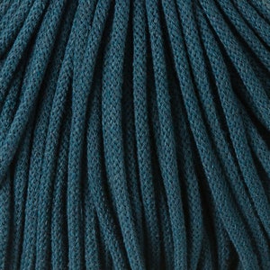 May include: Close-up of a deep teal cotton cord, showing the texture and weave of the material.