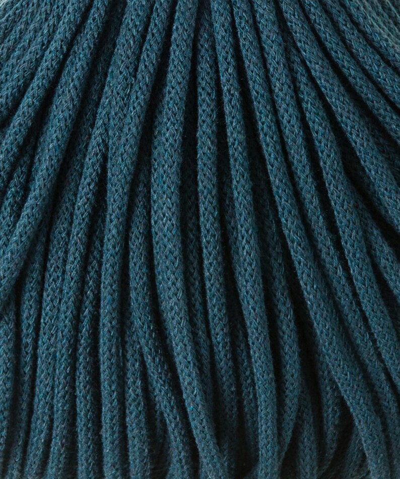 May include: Close-up of a deep teal cotton cord, showing the texture and weave of the material.