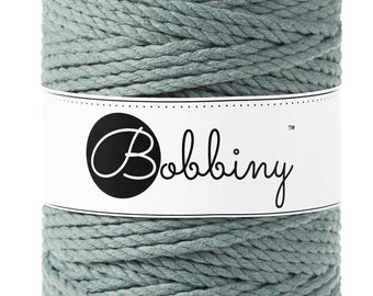 Könnte beinhalten: Eine Rolle blaugrüne Baumwollschnur mit einem weißen Etikett, auf dem "Bobbiny™" steht.