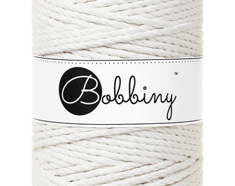 Könnte beinhalten: Eine weiße Rolle aus Baumwollschnur mit einem Etikett mit der Aufschrift "Bobbiny™".