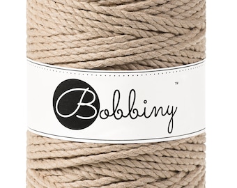 May include: A spool of natural beige cotton rope with the brand name "Bobbiny" printed on a white label.