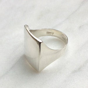 May include: A silver signet ring with a square face and the inscription "SARAH BEATLY" on the band.