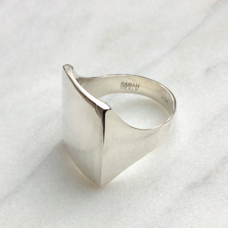 May include: A silver signet ring with a square face and the inscription "SARAH BEATLY" on the band.