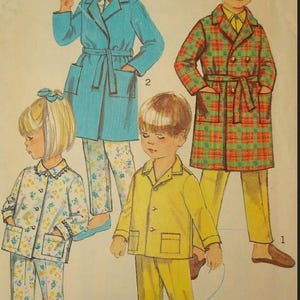 May include: Vintage Simplicity sewing pattern featuring children's pajamas and robes. The illustration shows four children in various pajama sets and robes. The robes are in blue and plaid, and the pajamas are yellow and floral. The text "Simplicity" is at the top.