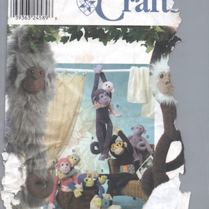 May include: Simplicity Craft pattern featuring various plush monkey designs. The image shows several stuffed monkeys in different poses, some hanging, others in a basket. The pattern includes the text "ONE SIZE" and a barcode.