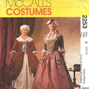 Może przedstawiać: Koperta z wykrojem krawieckim McCall's 2253 przedstawiająca dwa kostiumy w stylu historycznym. Kostium A zawiera kwiecisty gorset i różową spódnicę, natomiast kostium B to ciemnoczerwona sukienka z białym fartuchem i niebieską wstążką.