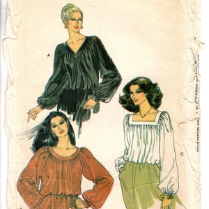 May include: A vintage Vogue Patterns sewing pattern envelope, number 7247, size 16. The illustration displays three blouse variations: a dark green V-neck top, a rust-colored round-neck top with a waist tie, and a white square-neck top with long sleeves.