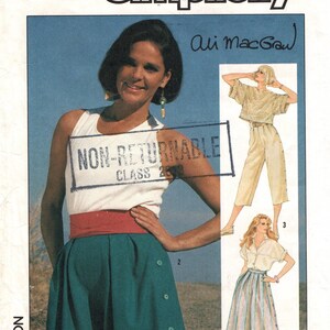 May include: Vintage Simplicity sewing pattern featuring Ali MacGraw. The pattern includes designs for a skirt, pants, and a top. The image shows a woman wearing a white top, teal skirt, and red belt. The text "NON-RETURNABLE CLASS 2848" is visible.