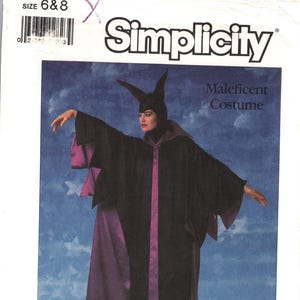 May include: Simplicity Patterns sewing pattern for a Maleficent costume. The pattern features a black cloak with purple accents, a matching headpiece with horns, and the Walt Disney logo. Size 6 & 8.