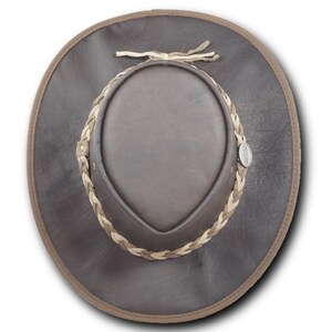 May include: A brown leather cowboy hat with a braided leather band and a small metal tag that says "AUSTRALIAN MADE".