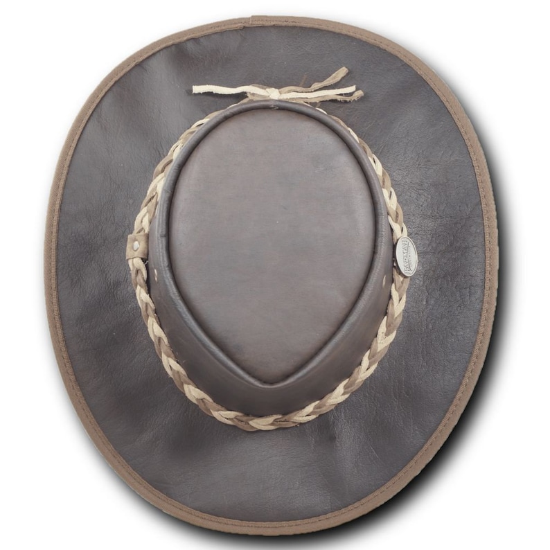 May include: A brown leather cowboy hat with a braided leather band and a small metal tag that says "AUSTRALIAN MADE".