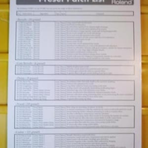 Puede incluir: Un papel blanco titulado "Preset Patch List" para un sintetizador Roland VSBF-1. La lista está dividida en secciones para Reverb, Chorus, Delay, Vocals y Guitar, con numerosos nombres y descripciones de presets. El papel está sobre una superficie amarilla.