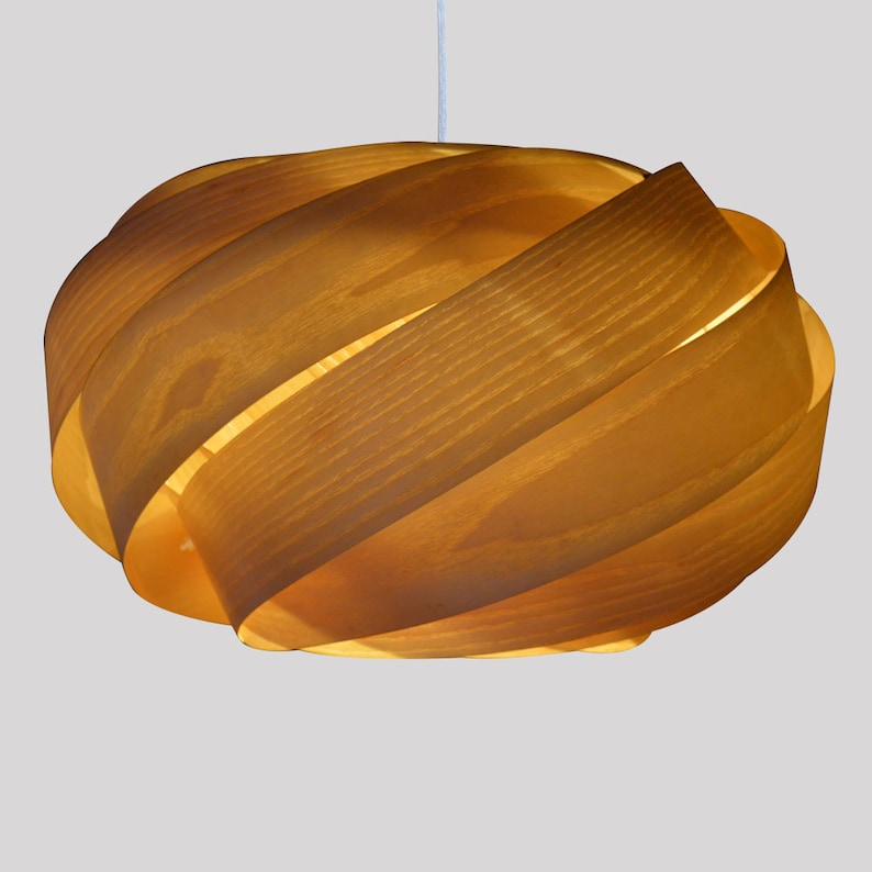 May include: A wooden pendant light fixture with a unique, swirling design. The light is made of multiple layers of wood that are woven together to create a unique and modern look.