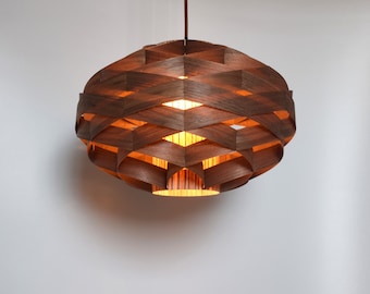 May include: A brown wooden pendant light fixture with a woven design. The light is on and casting a warm glow.