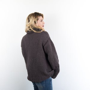 Het vest van de vrouw in lange wol bij de ijzers, elegant gebreide vest en minimaal chique damesjasje met kraag afbeelding 9